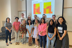 A group of students in front of a climate change presentation.